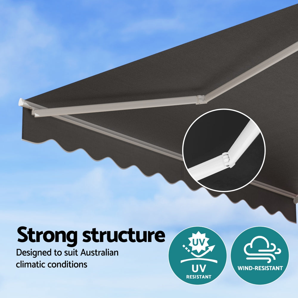 Grey retractable awning with white support arms and underside scalloped valance