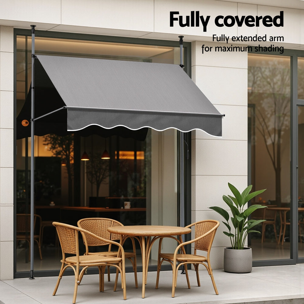 Grey window awning with extended pivot arms and scalloped valance