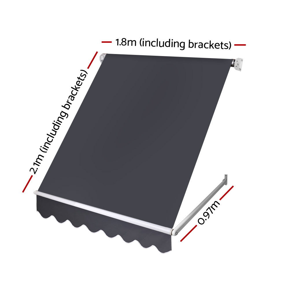 Outdoor window awning with dark gray canopy fabric, white frame, and scalloped valance