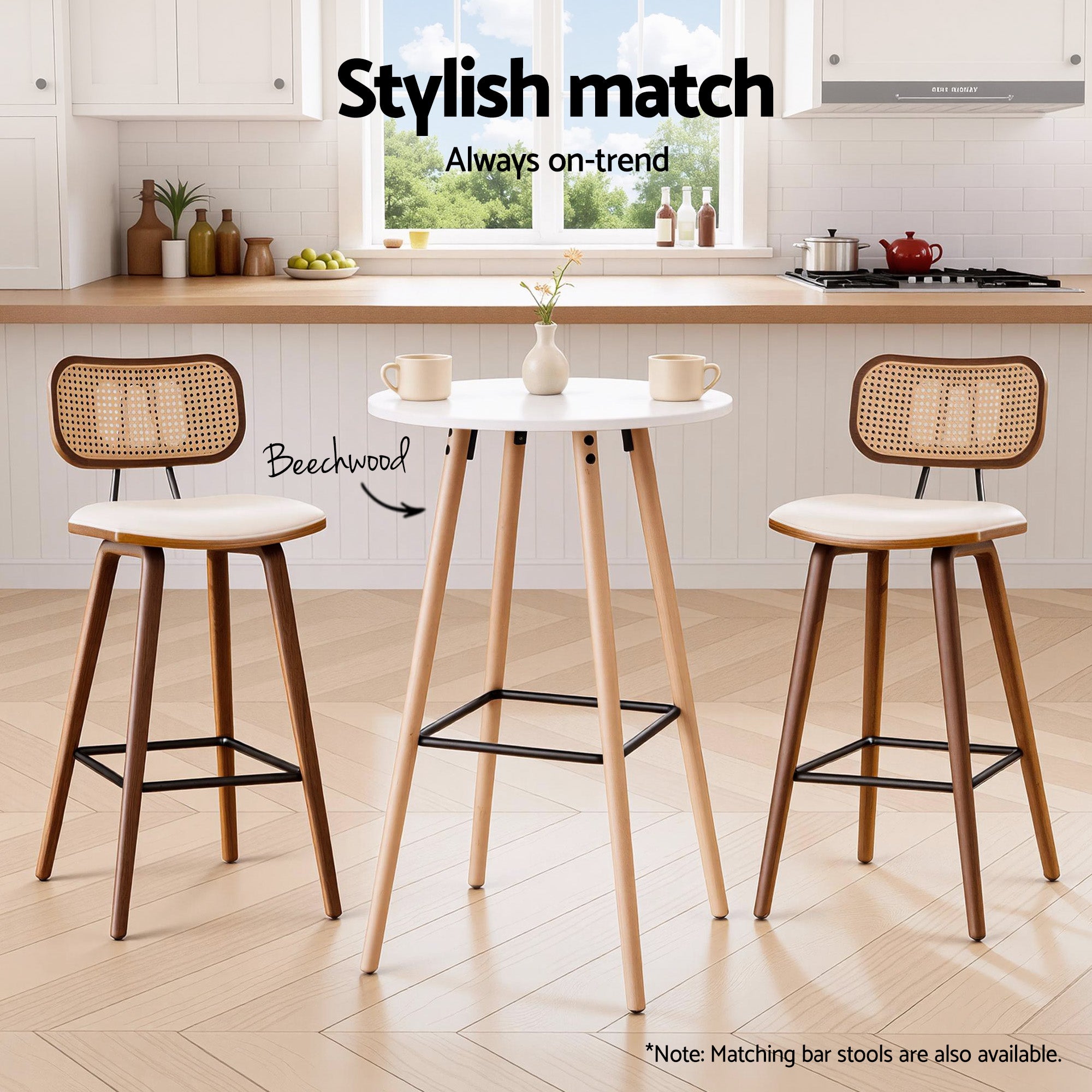 Round bar table with white top, light wood legs, and black metal footrest