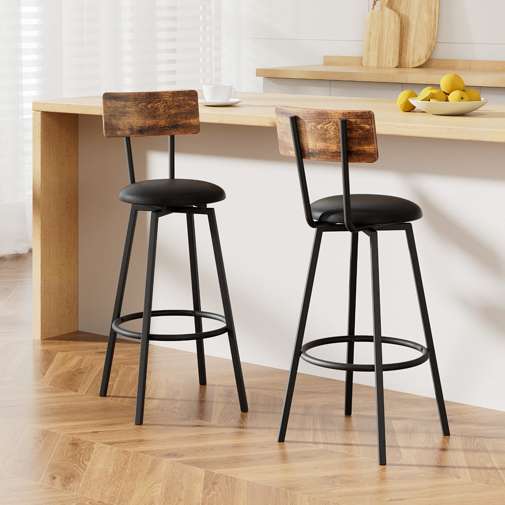 Set of two industrial bar stools with black seats, brown wood backrests, and metal footrests