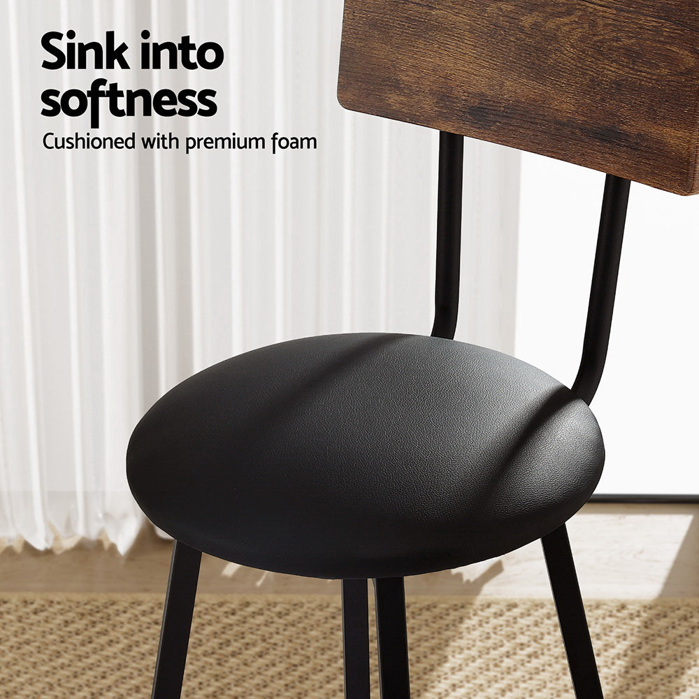Industrial bar stool with black cushioned seat and brown wooden backrest, arched footrest