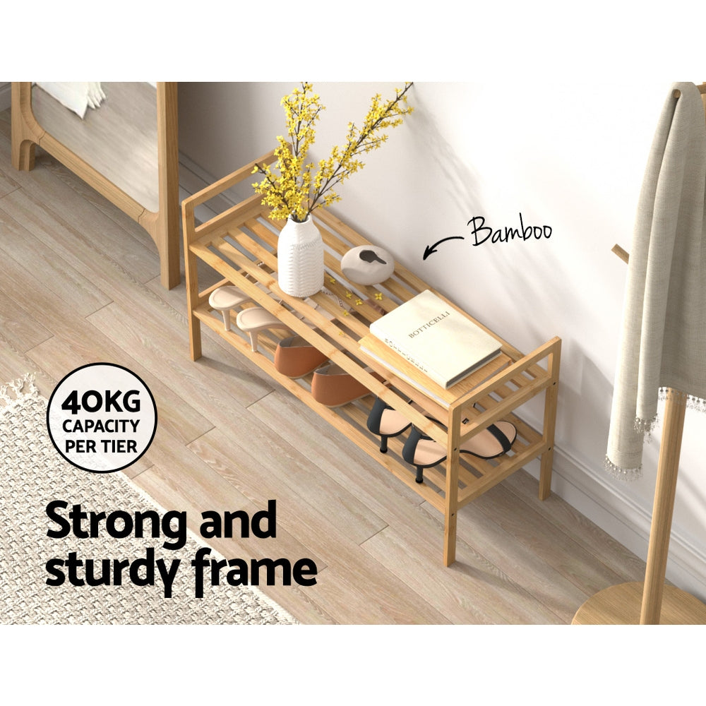 Bamboo shoe rack with two-tier open shelves, small items and shoes on lower shelf.