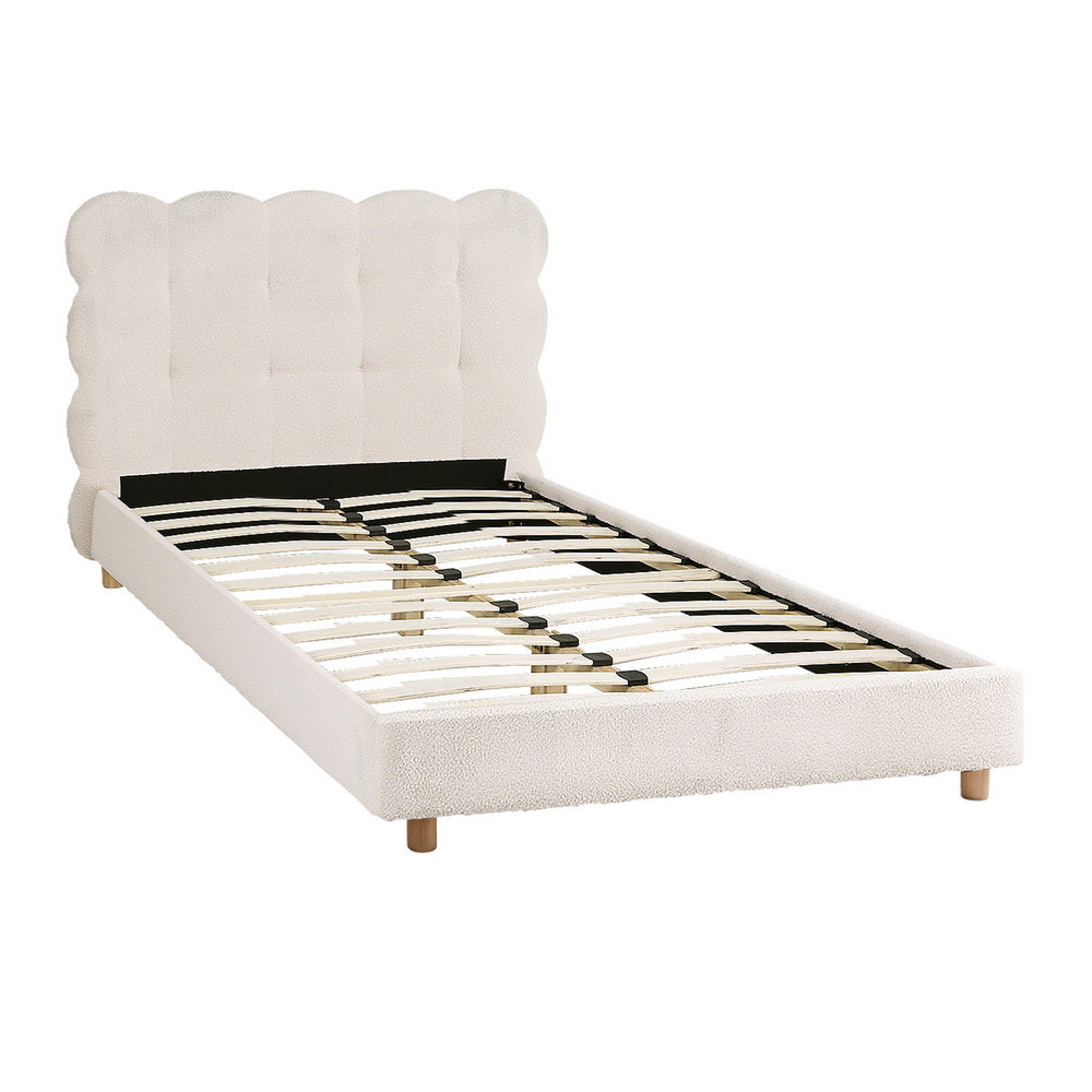 White upholstered platform bed frame with scalloped cloud headboard and matching foot