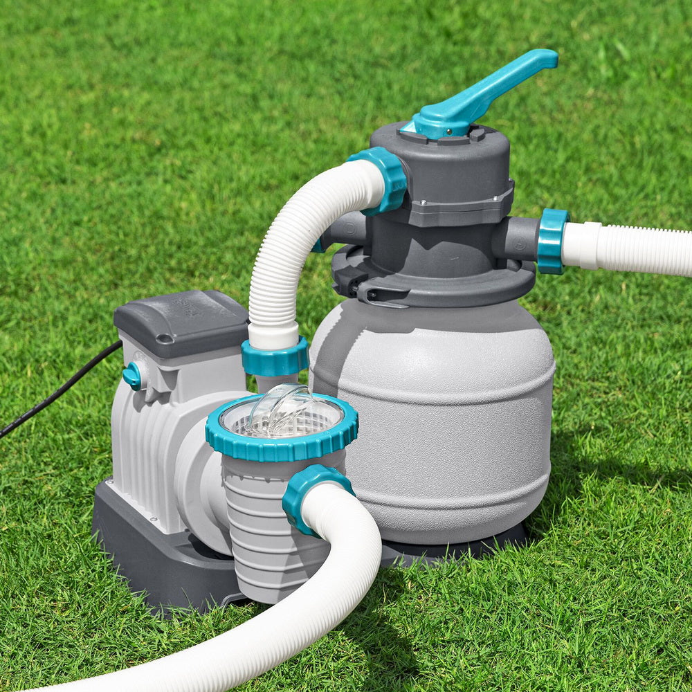 Pool sand filter pump with teal handle and white hoses on dark base