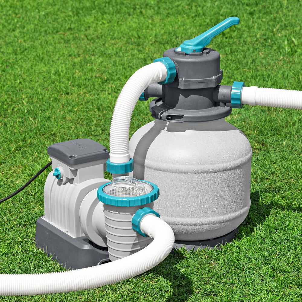 Sand filter pump with grey tank, teal valve handle, and white hose fittings
