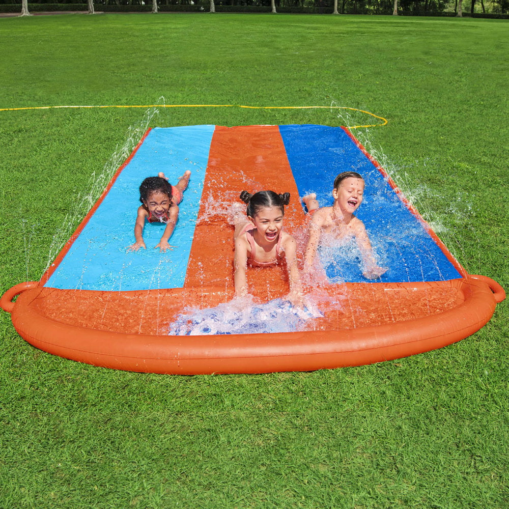 Triple-lane inflatable water slide with orange rim and blue/orange lanes, kids playing