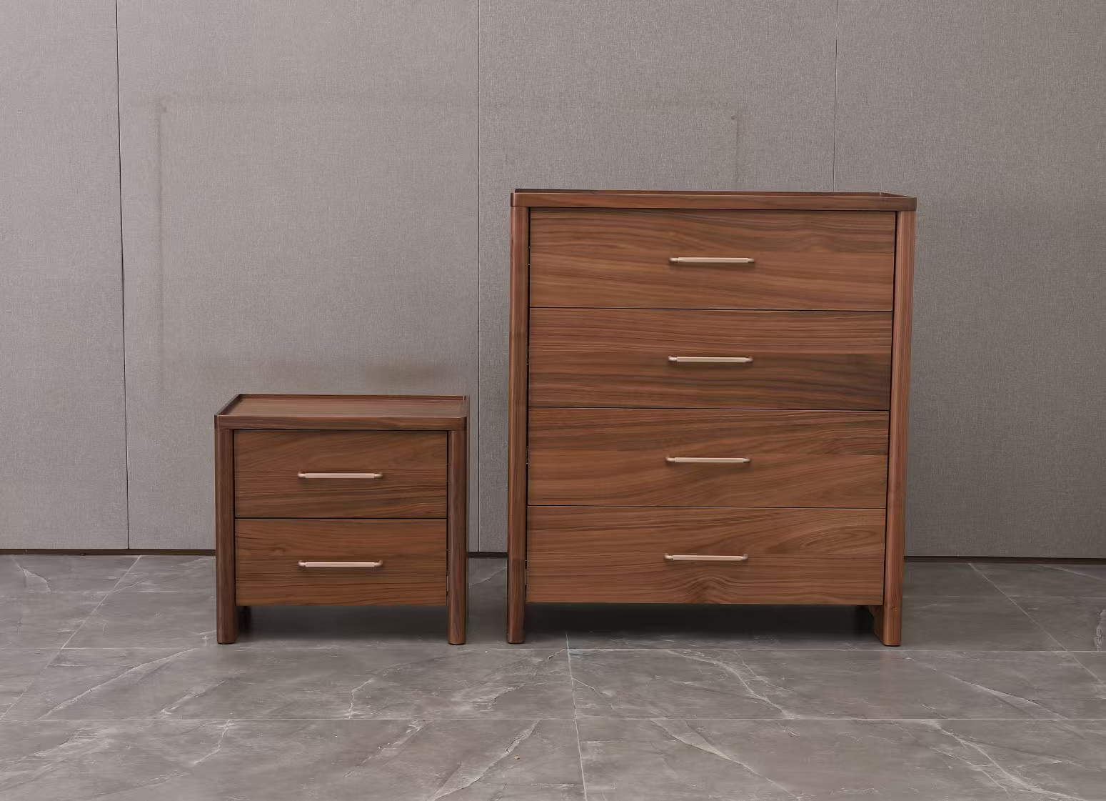 Wooden dresser and nightstand with four drawers on a gray floor and wall.