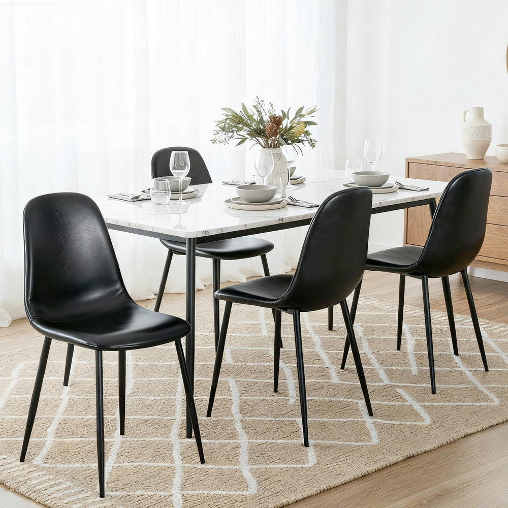 Black PU leather dining chairs with curved backs and seats on slim metal legs