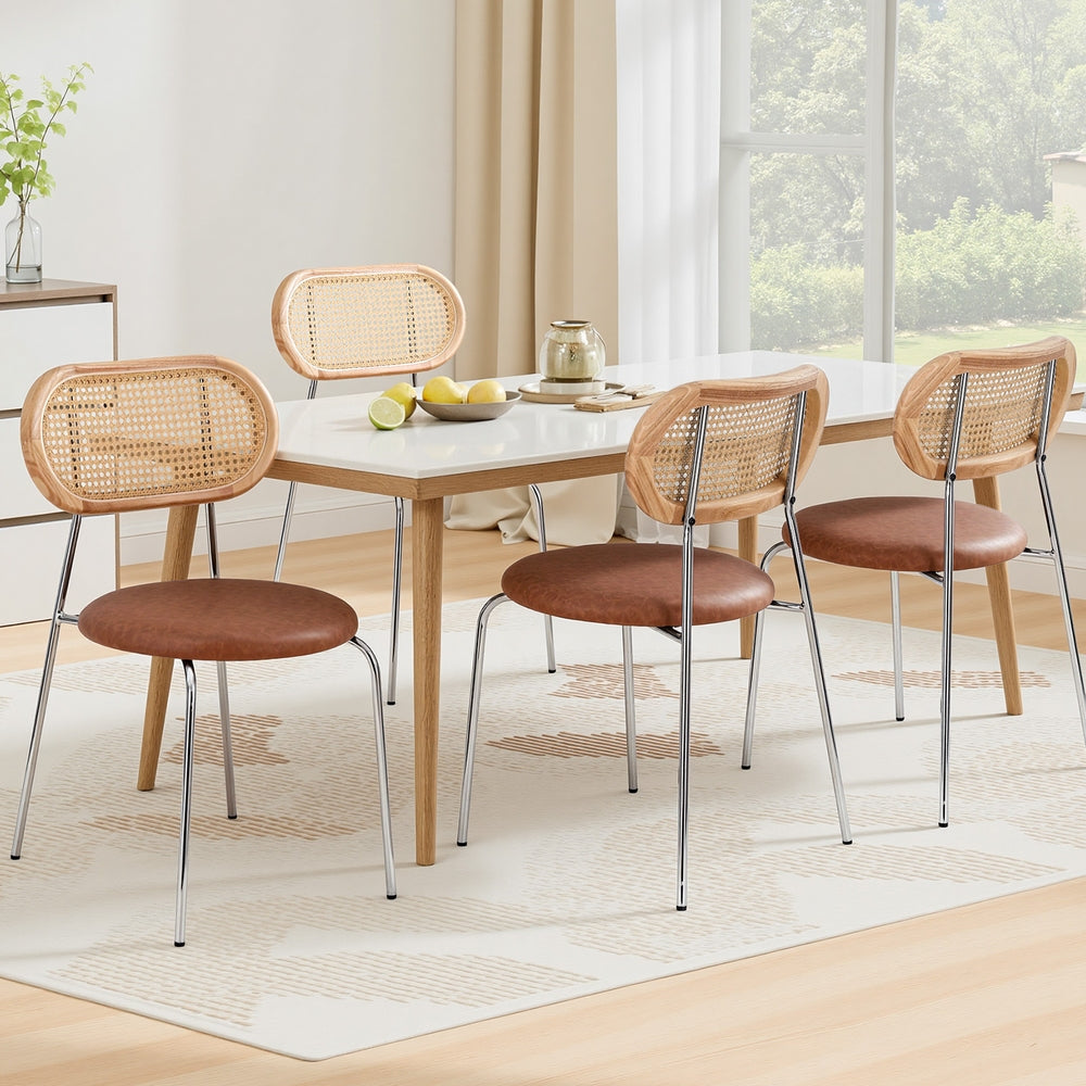 Four dining chairs with rattan-style backrests and brown round seats, chrome metal legs.