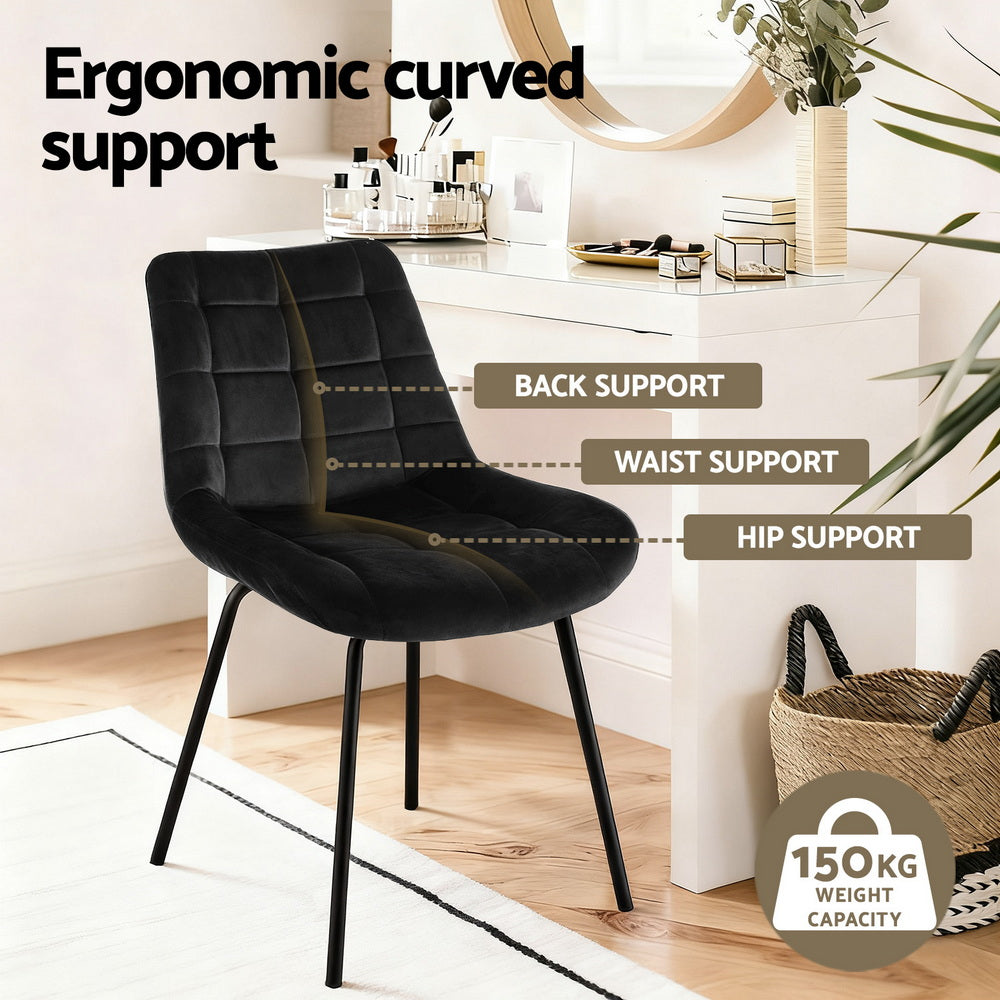Black velvet dining chair with tall arched back and cushioned seat, angled metal legs