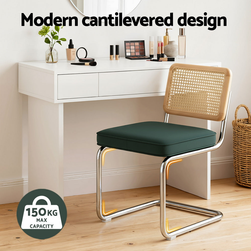Cantilever dining chair with green cushioned seat and woven rattan back on chrome base
