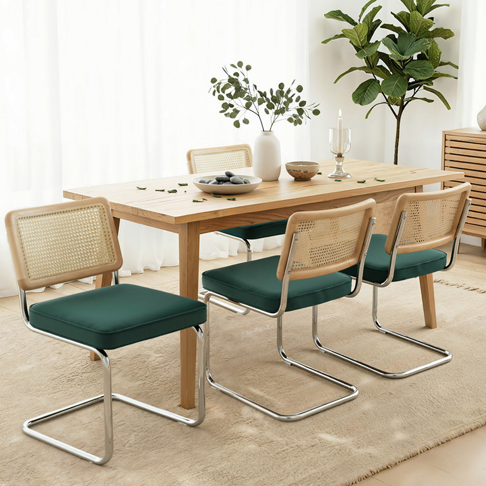 Set of four cantilever dining chairs with green upholstered seats and rattan woven backs
