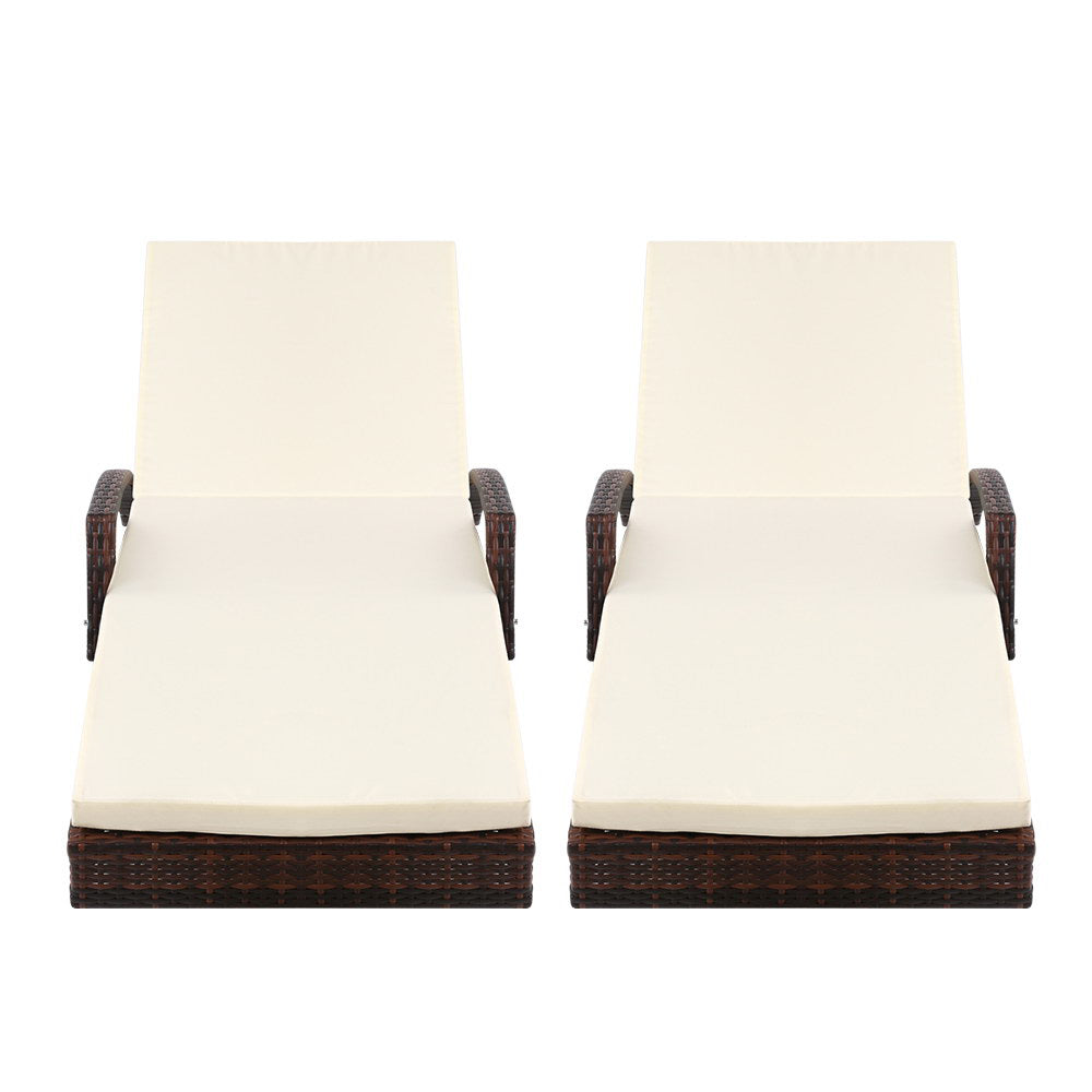 Two lounge chairs with cream cushions and dark brown wicker frames, backrests upright