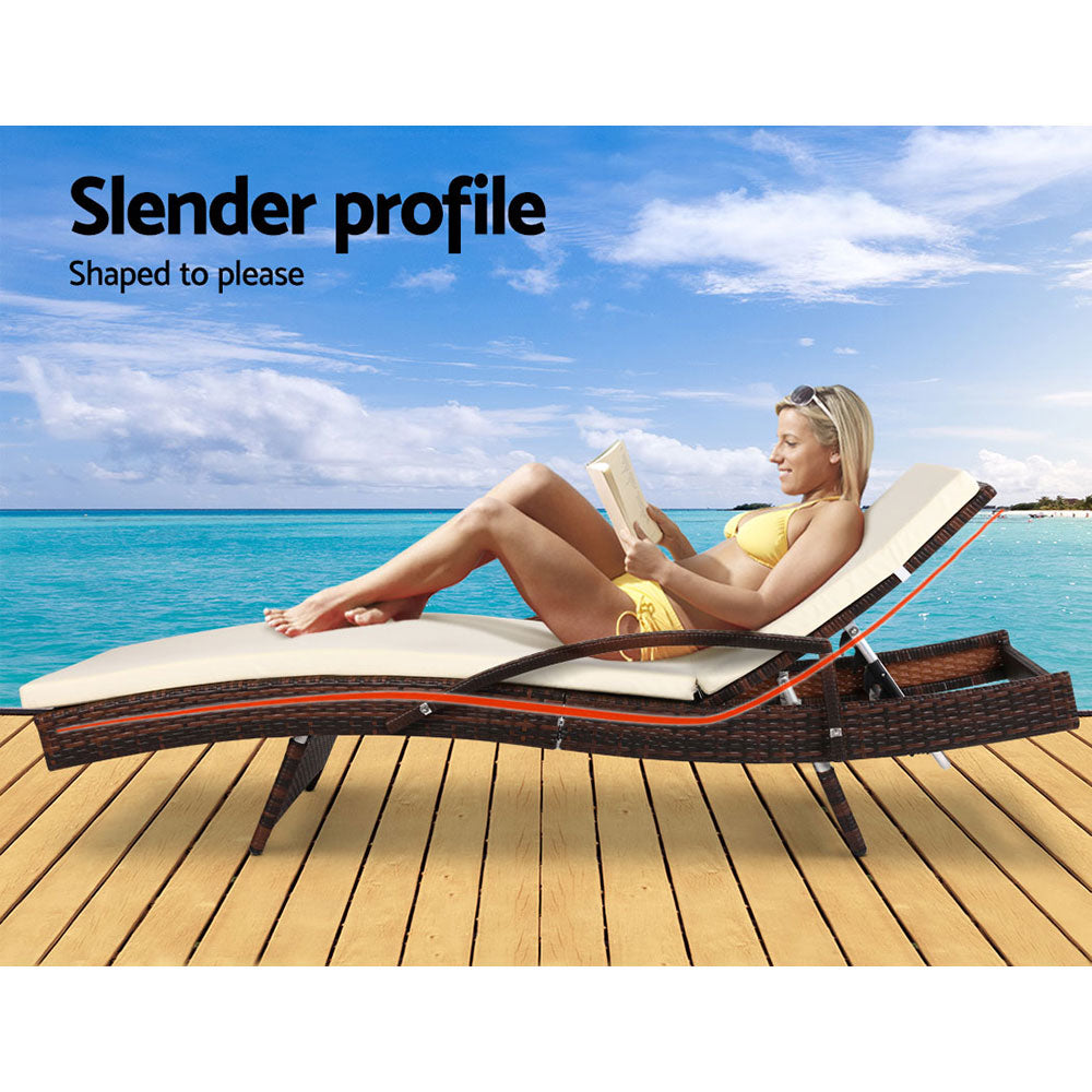 Adjustable brown wicker lounge chair with cream cushion and arched armrests, reclined