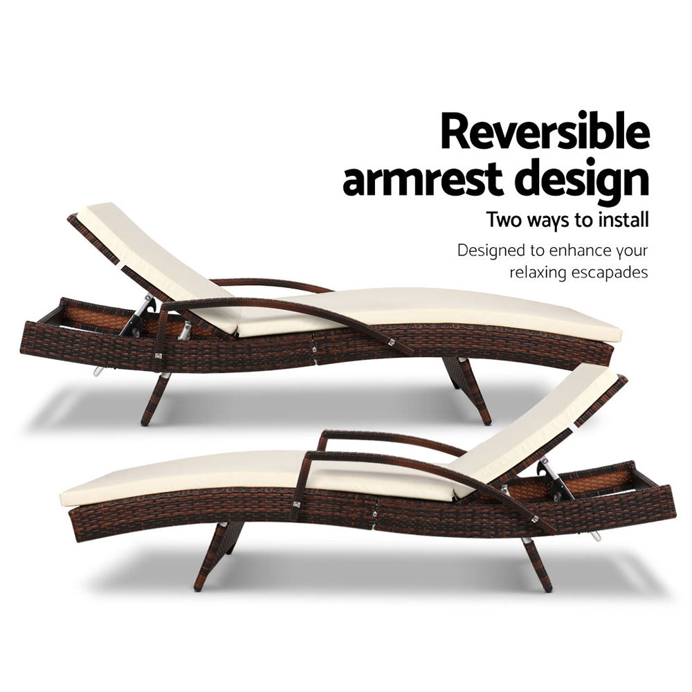 Two brown wicker lounge chairs with cream cushions and reversible armrest design