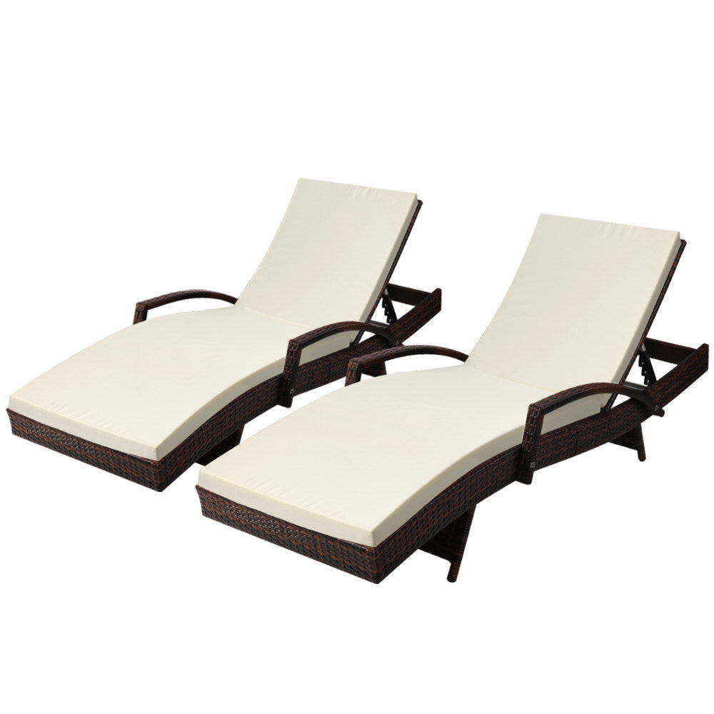 Two brown wicker adjustable loungers with cream seat cushions and curved backrests