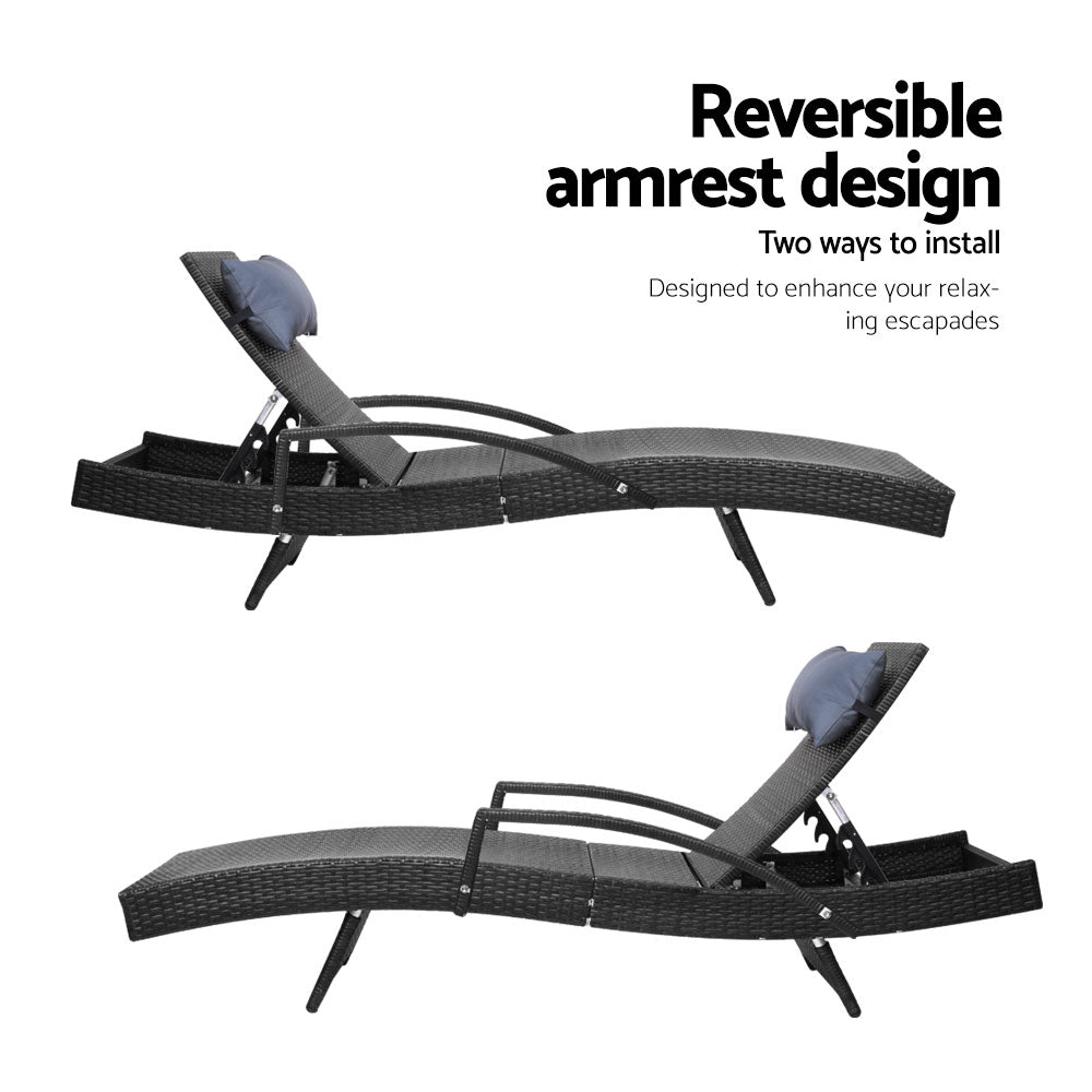 Black woven wicker sun lounger with padded headrest, arched support frame, and armrest