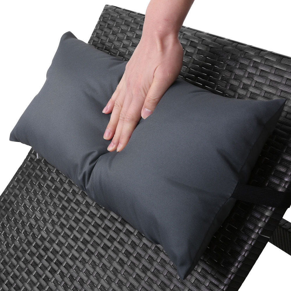 Black woven wicker lounge chair with dark gray padded cushions, shown from close-up angle