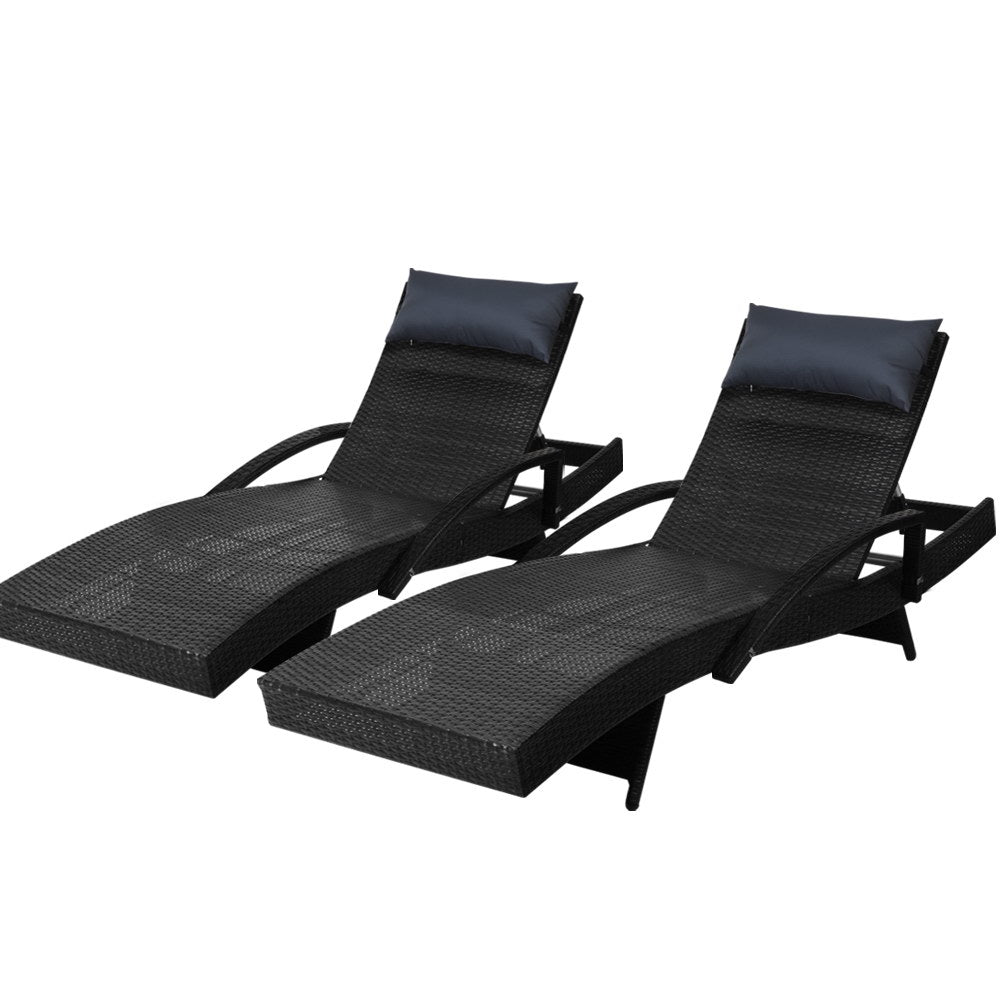Two black woven wicker sun loungers with padded headrests, reclining seats, and armrests