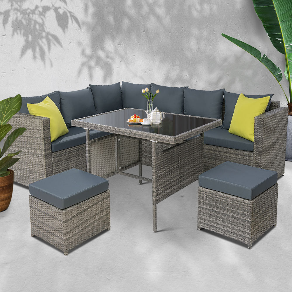 Outdoor dining set with grey wicker-look sectional, dark cushions, yellow pillows and table