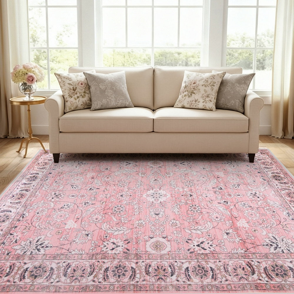 Pink vintage floral area rug with ornate border, flat woven look