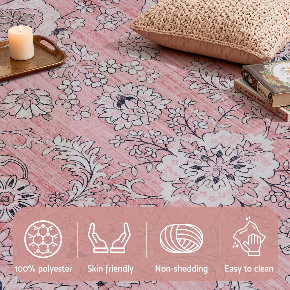 Pink vintage floral rug with large white flower motifs and scrolling linework.