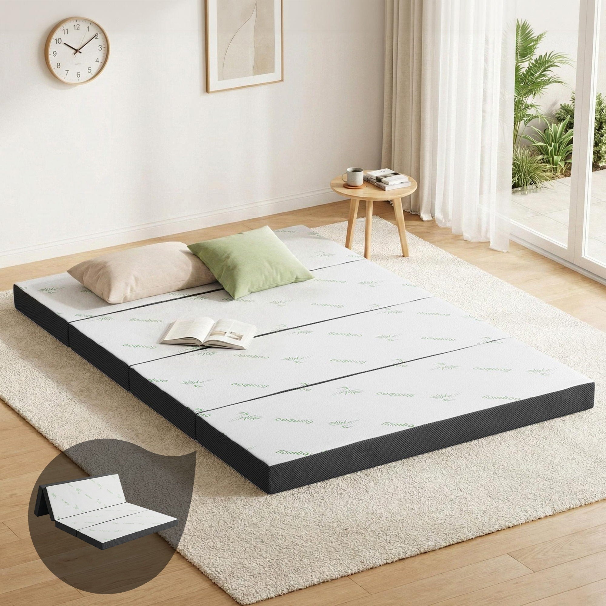 Foldable double mattress on floor, white bamboo-pattern top with dark side trim