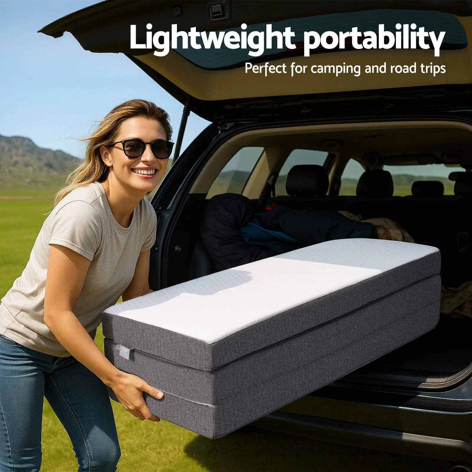 Foldable mattress in a car trunk with dark gray base and light gray top