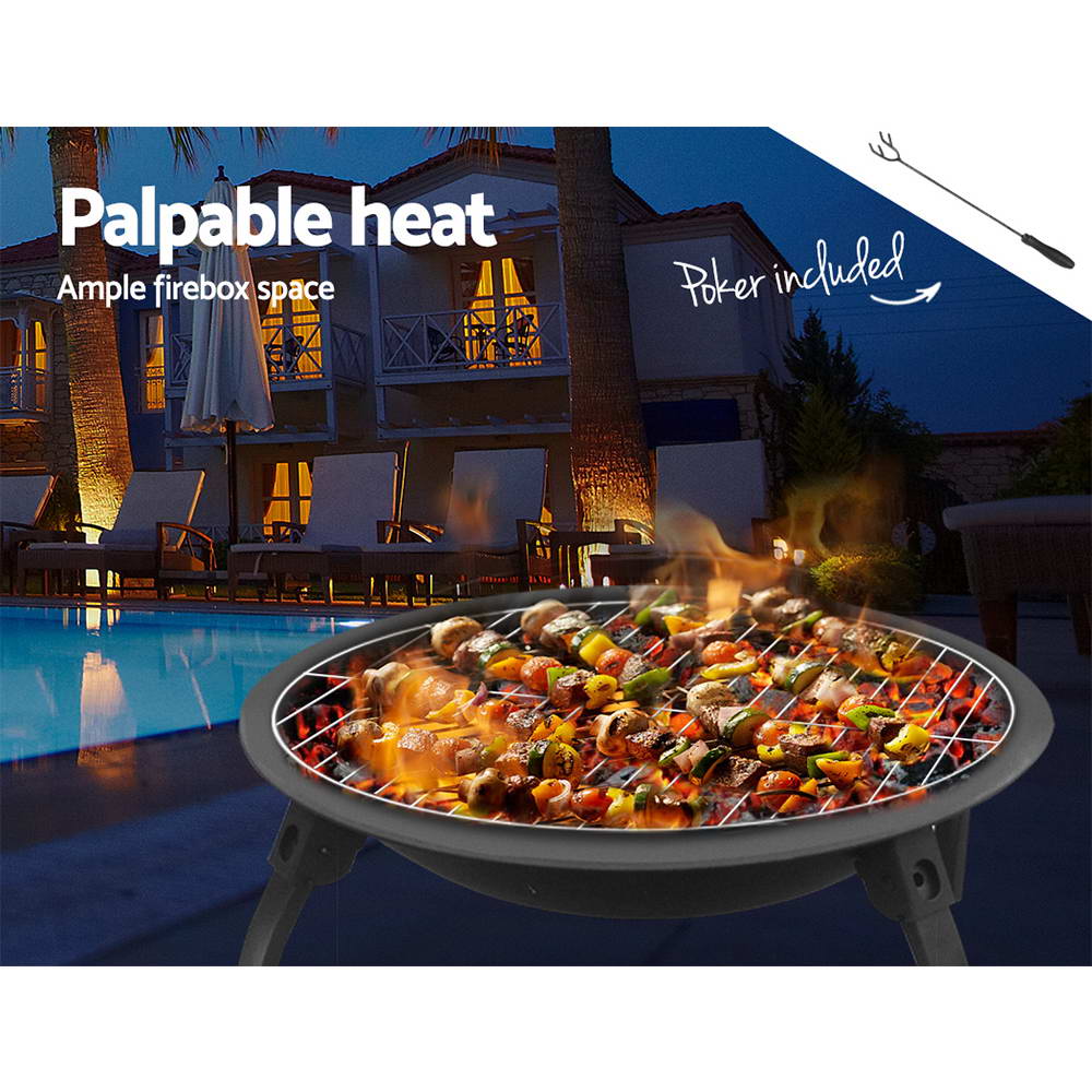 Portable charcoal BBQ fire pit grill with food cooking over glowing coals