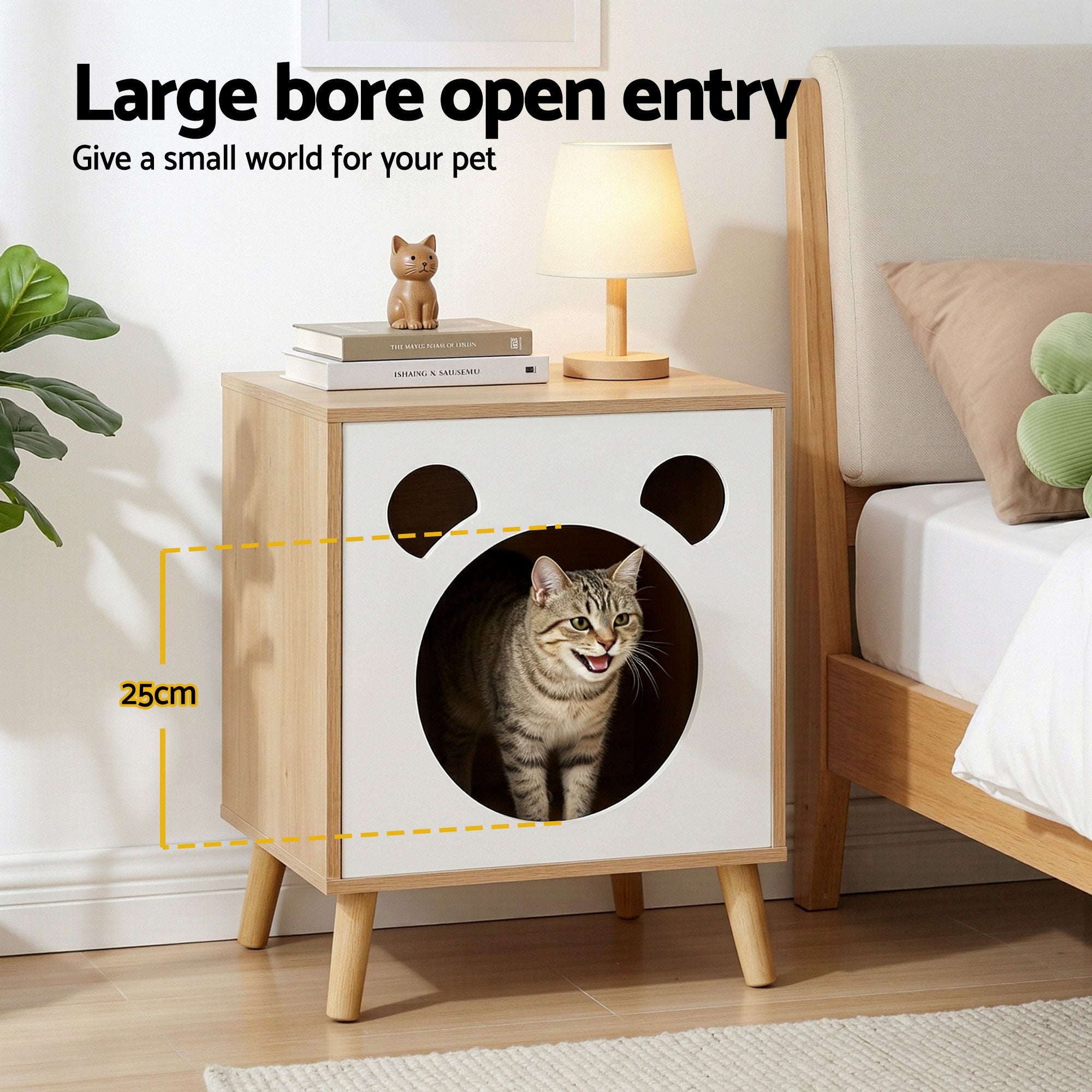 Cat nest bedside table in living room, white front with round cat opening; tabby cat inside.