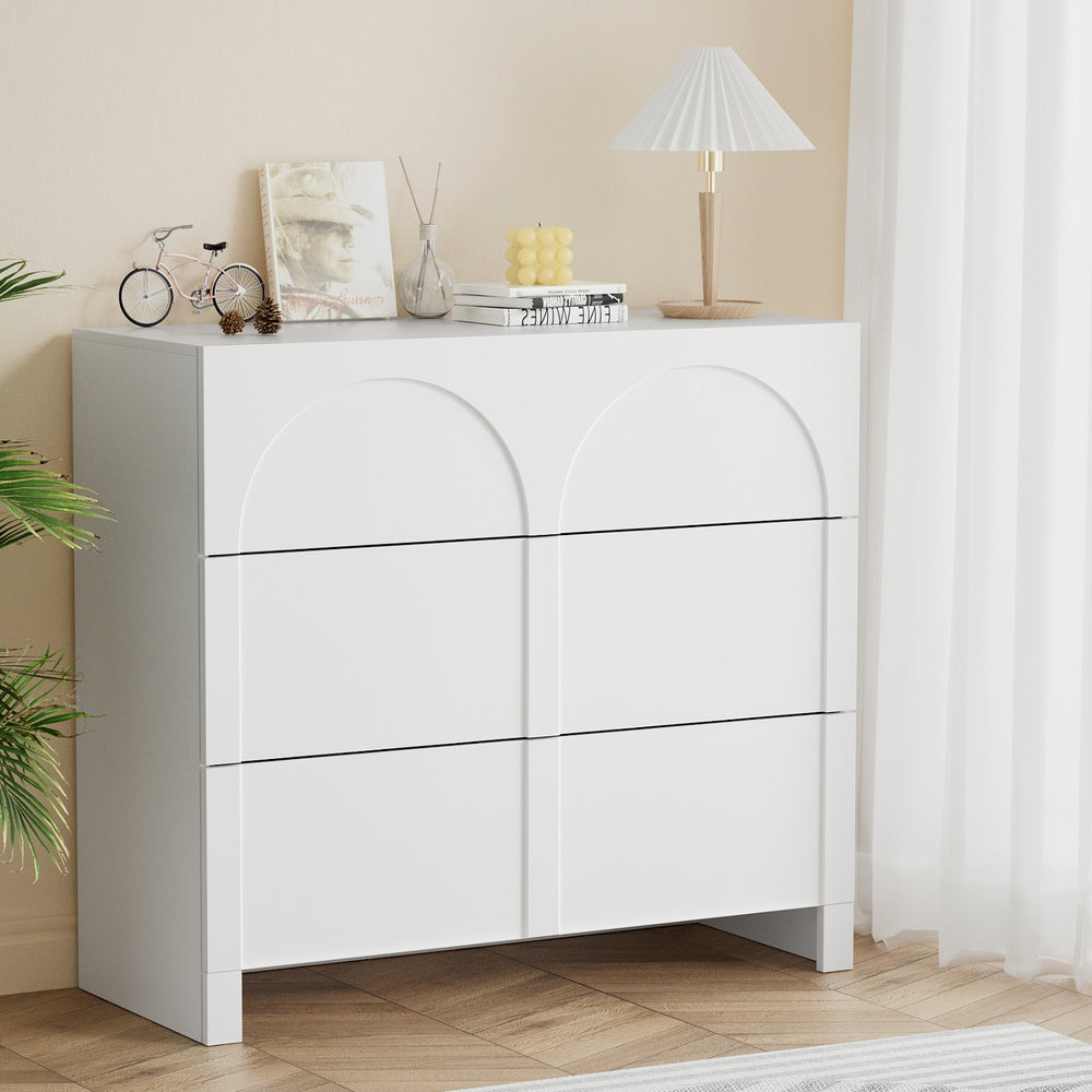 White lowboy dresser cabinet with arched panel drawer fronts, angled side view