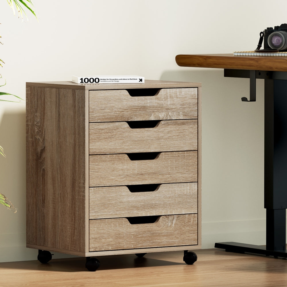 Rolling filing cabinet with five drawers, beige wood-look finish, black pull handles, caster feet