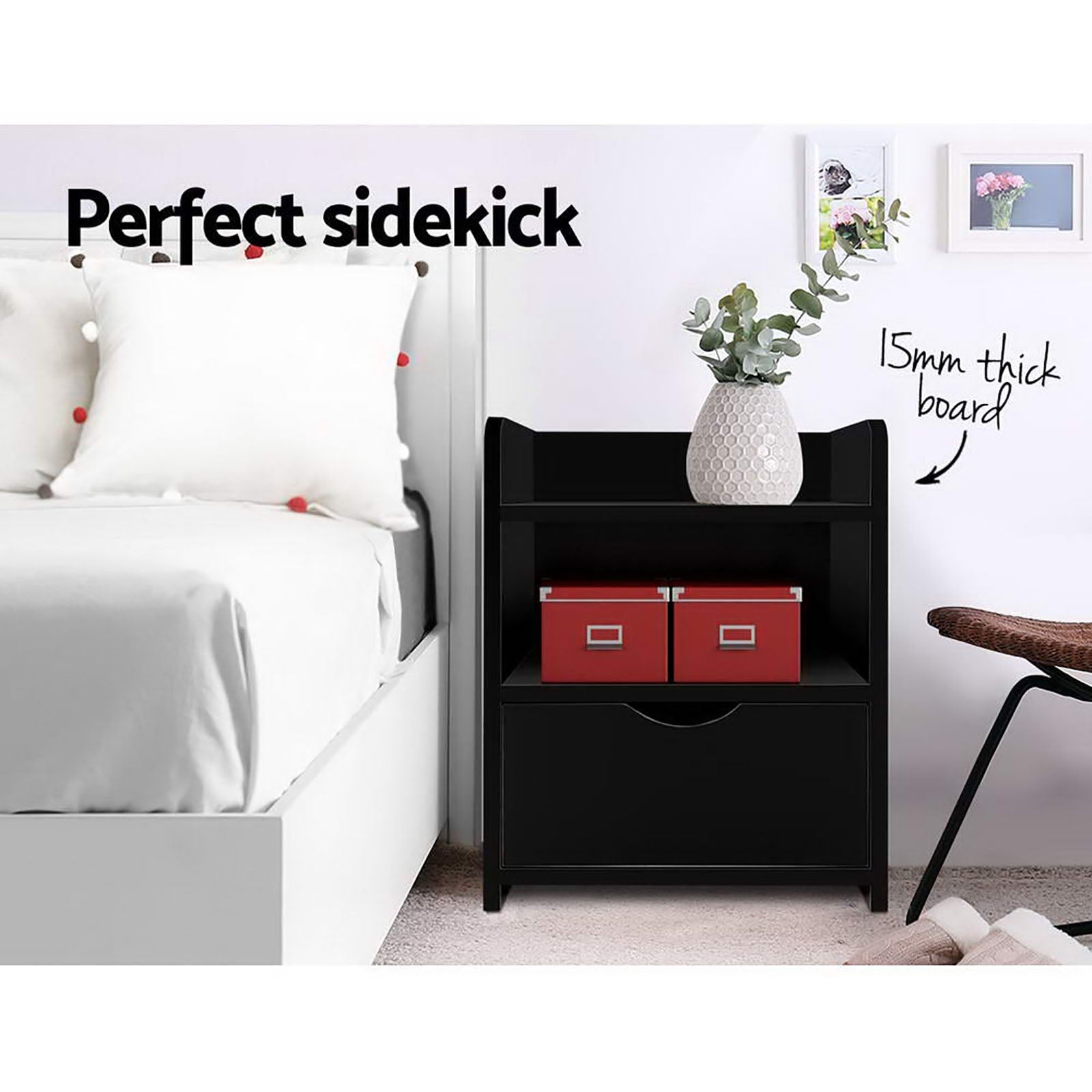 Black bedside table with open shelf and drawer, next to a bed