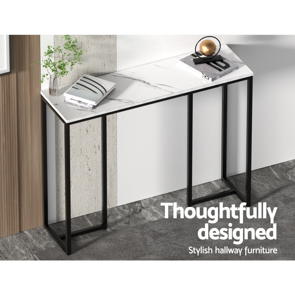 Console table with marble-effect top, black legs, and white panel fronts