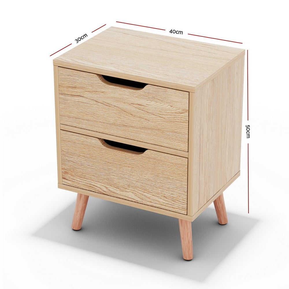 Light pine bedside table with two drawers and black handle cutouts, supported by tapered wooden legs.