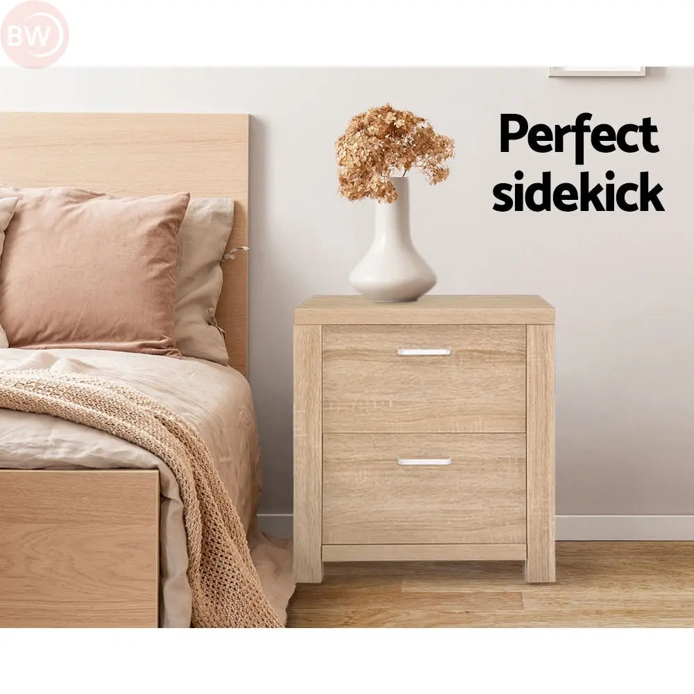 Light wood bedside table with two drawers and silver bar handles in bedroom