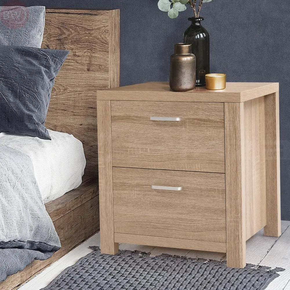 Light wood bedside table with two drawers and silver bar handles, corner view