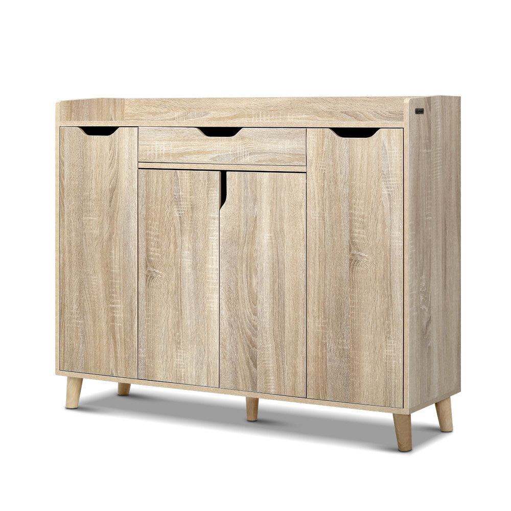 Light oak shoe rack cabinet with flip cubbies and closed door fronts on wooden legs