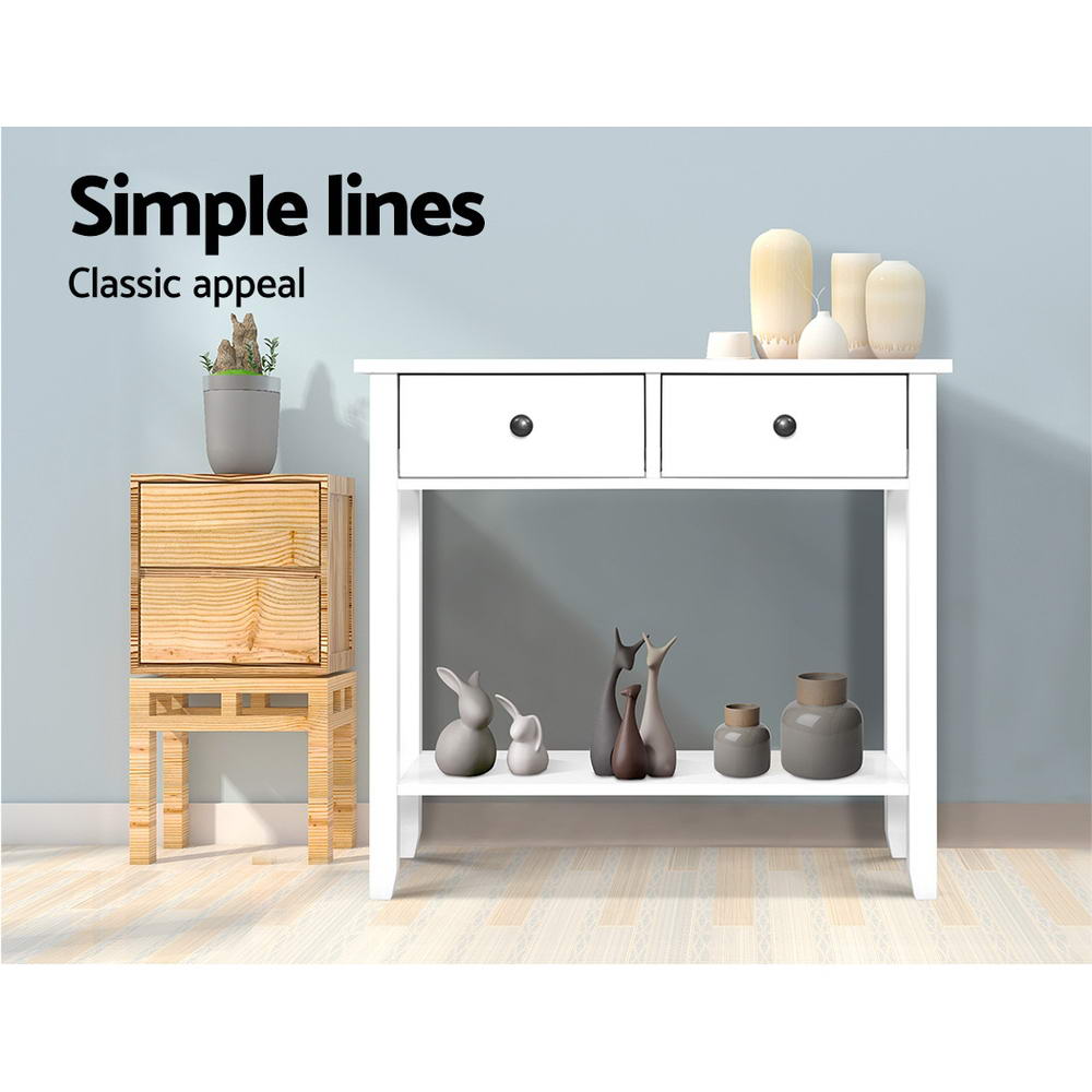 White console table with two drawers and open shelf, styled with vases and candles