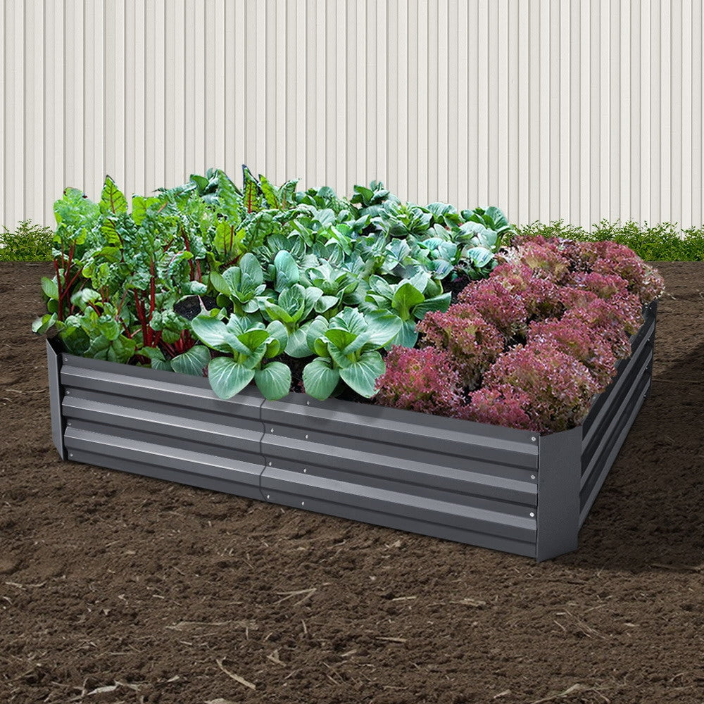Raised garden planter box with leafy greens and purple flowers inside, dark gray steel