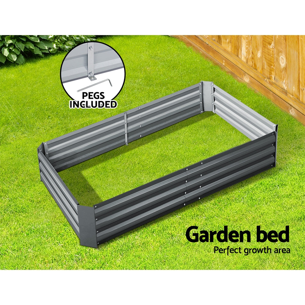 Raised garden planter box with corner pegs, slatted sides, dark gray steel on grass