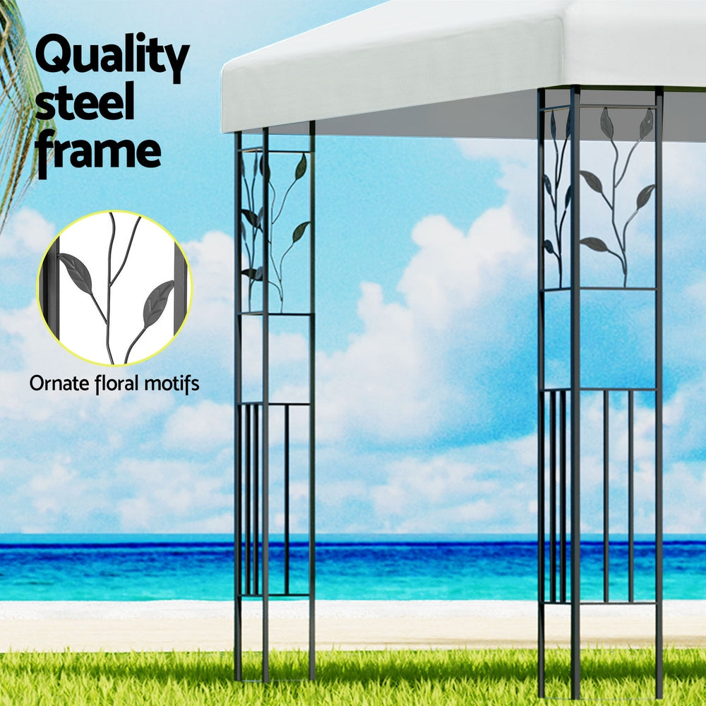 Iron gazebo frame with floral scrollwork on vertical panels and white canopy