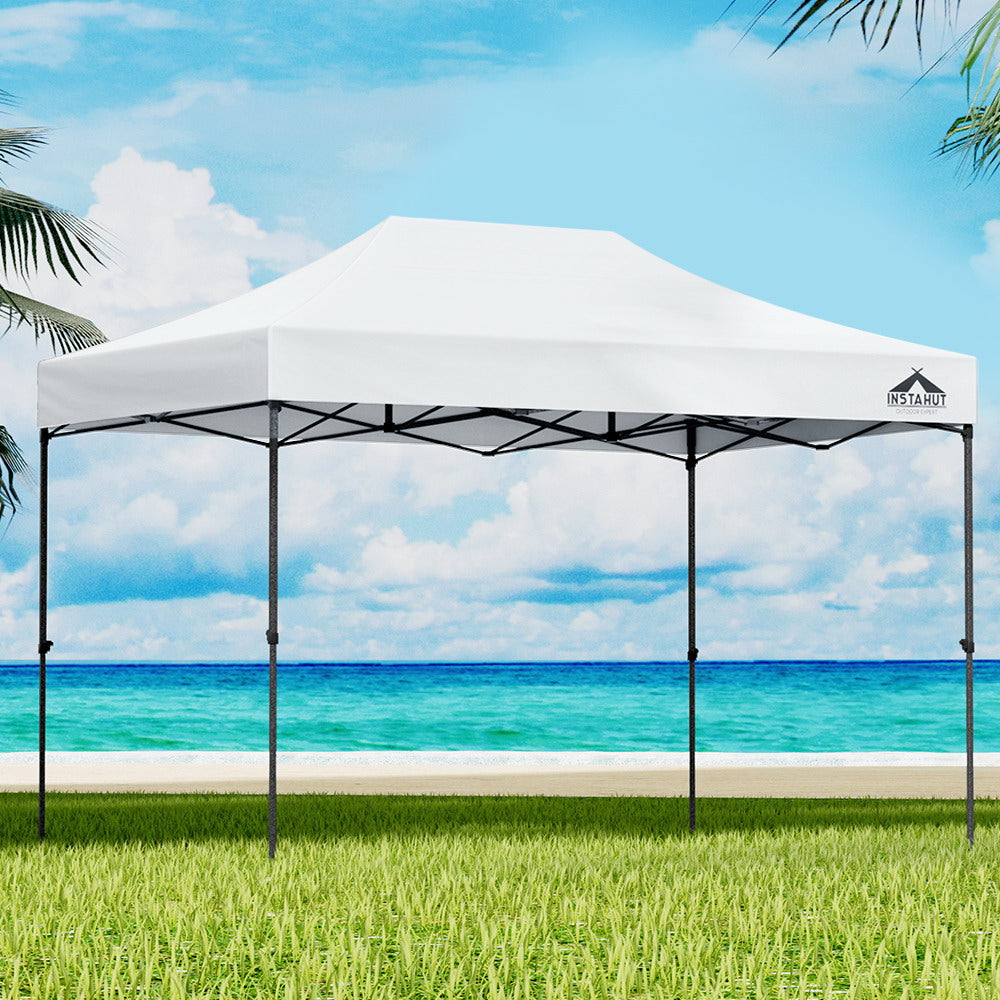 Pop-up marquee gazebo with white canopy and black frame over grass, open side panels