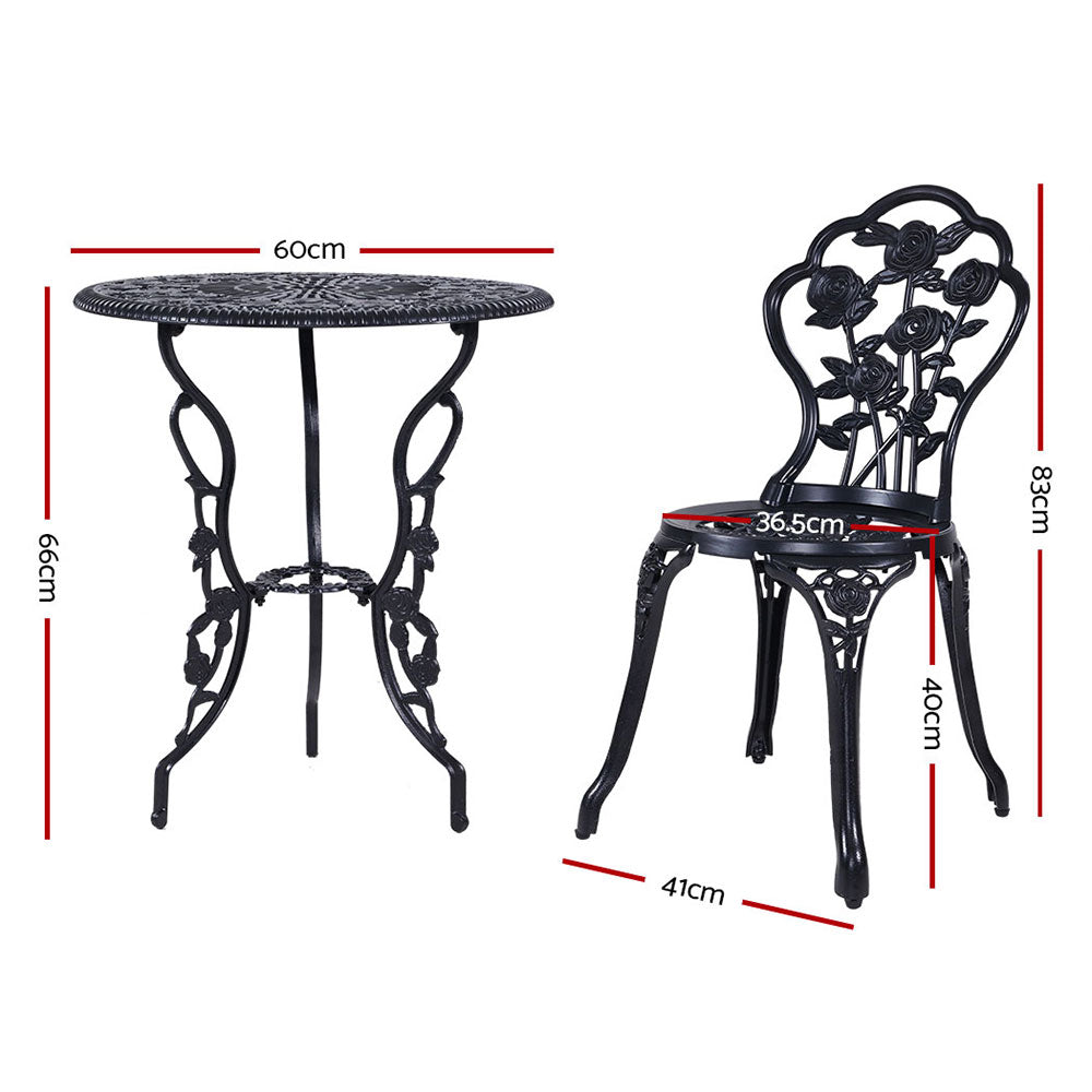Black bistro table with scroll pedestal base and matching rose-pattern chair, side view
