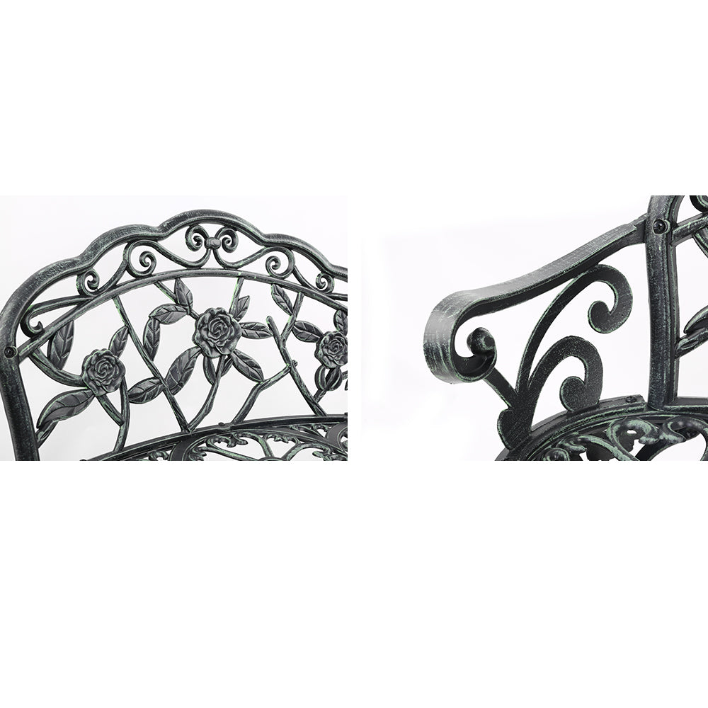 Cast aluminum bench seat close-up: floral back panel and curved side scrollwork, dark