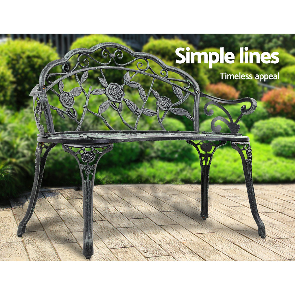 Cast aluminum garden bench seat with floral back, dark frame and green-tinted details