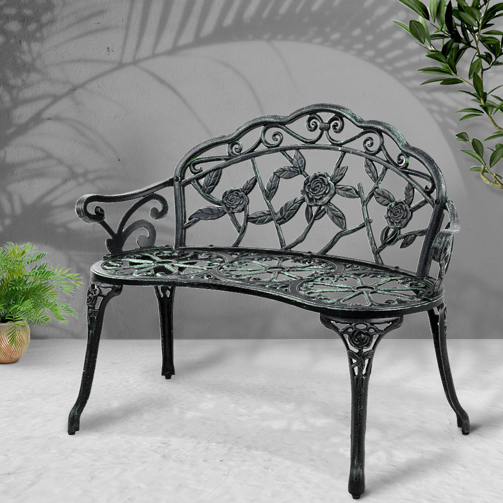 Cast aluminum garden bench seat with floral scrollwork back and decorative seat panel, dark