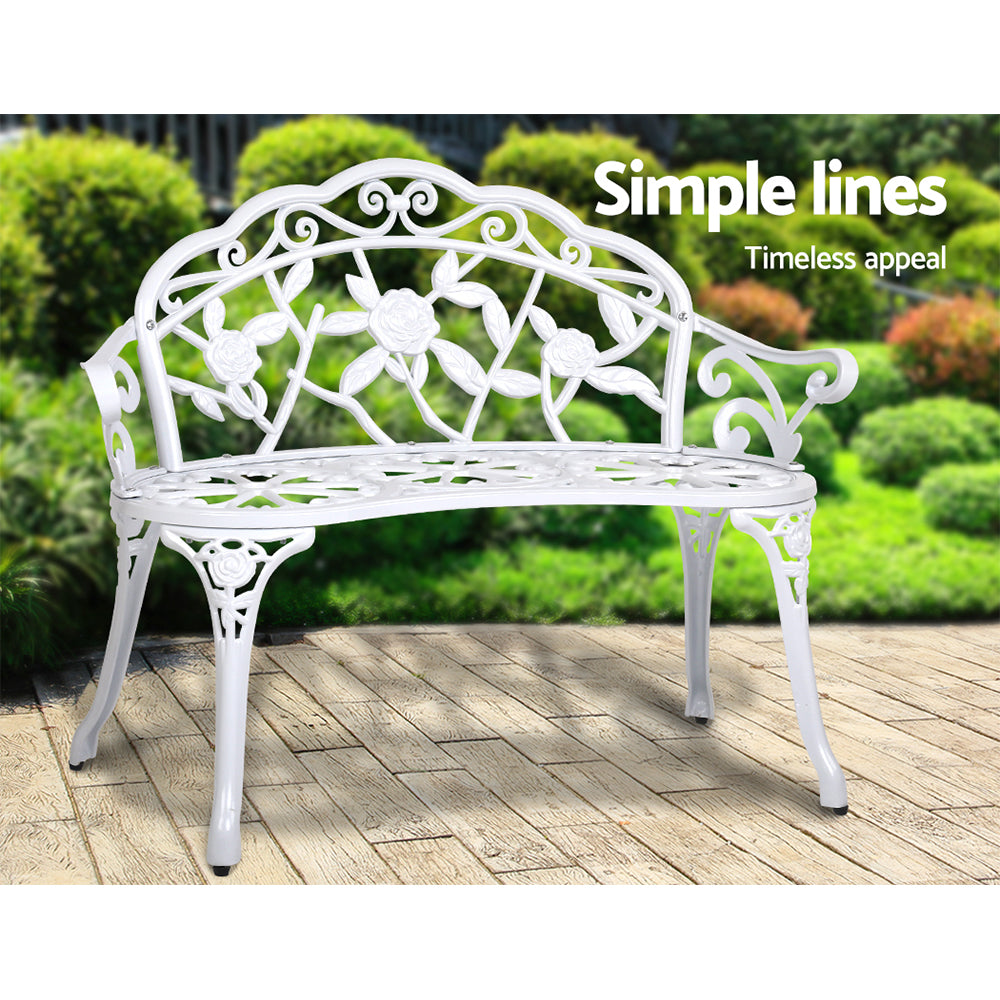 Vintage white cast aluminum outdoor bench chair with floral back panel and slatted seat