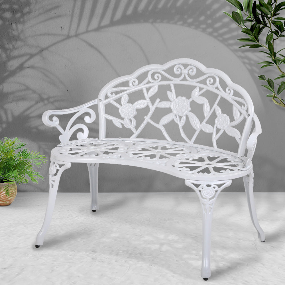 Vintage white cast aluminum bench chair with floral back grille and perforated slat seat
